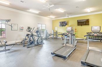 the gym with cardio equipment and weights at our apartments